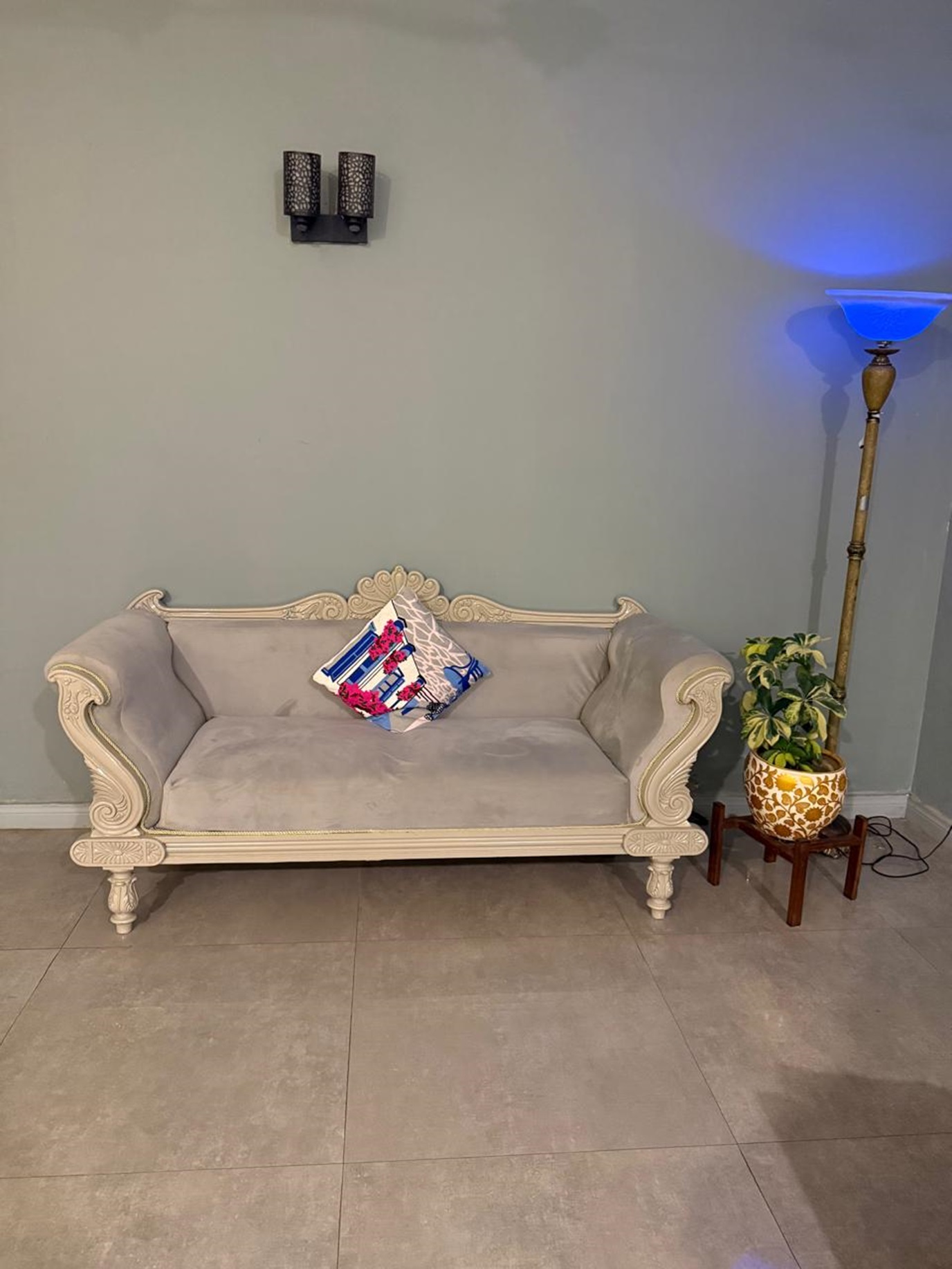Elegant beige sofa with decorative cushion and wooden legs